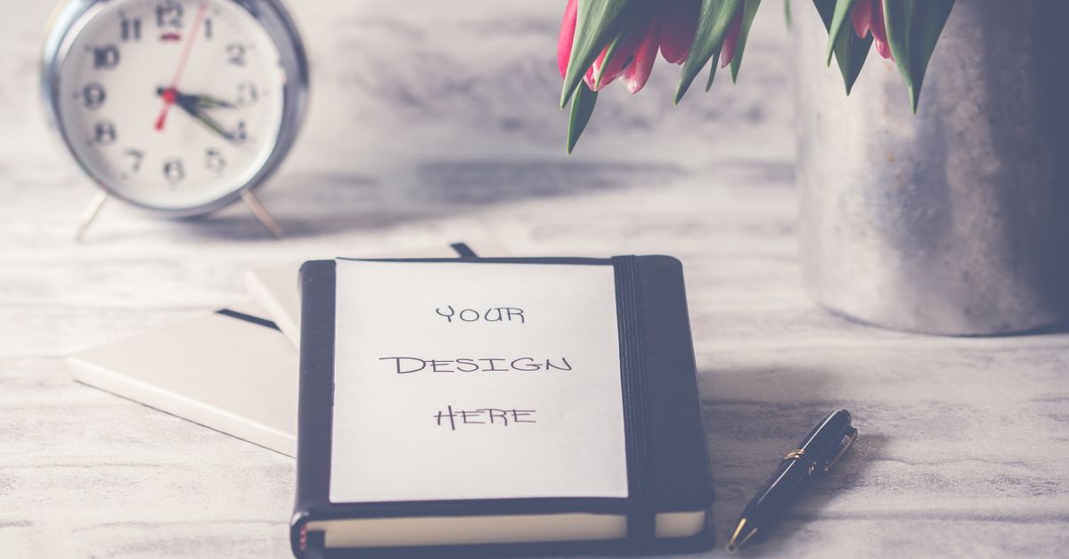 Stylish desk scene featuring tulips, a clock, and a notebook with customizable cover.
