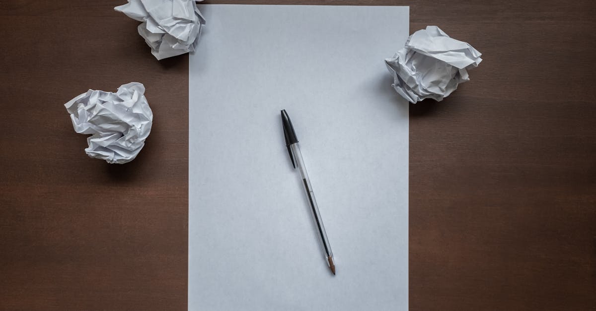 Crumpled paper and pen on desk, symbolizing writer's block or creativity struggles.