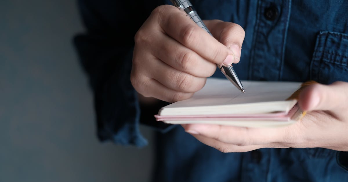 Hands writing in a notebook with a pen, capturing a moment of creativity and focus.