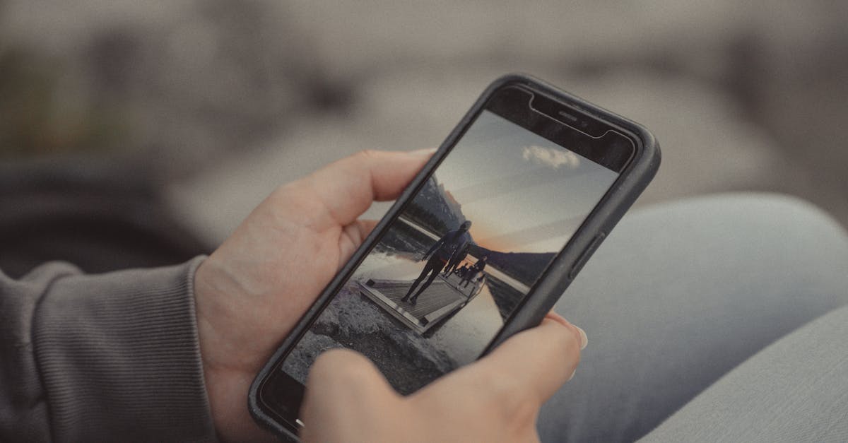 Close-up of hands holding a smartphone showing a mountain scene, captured outdoors in Banff.
