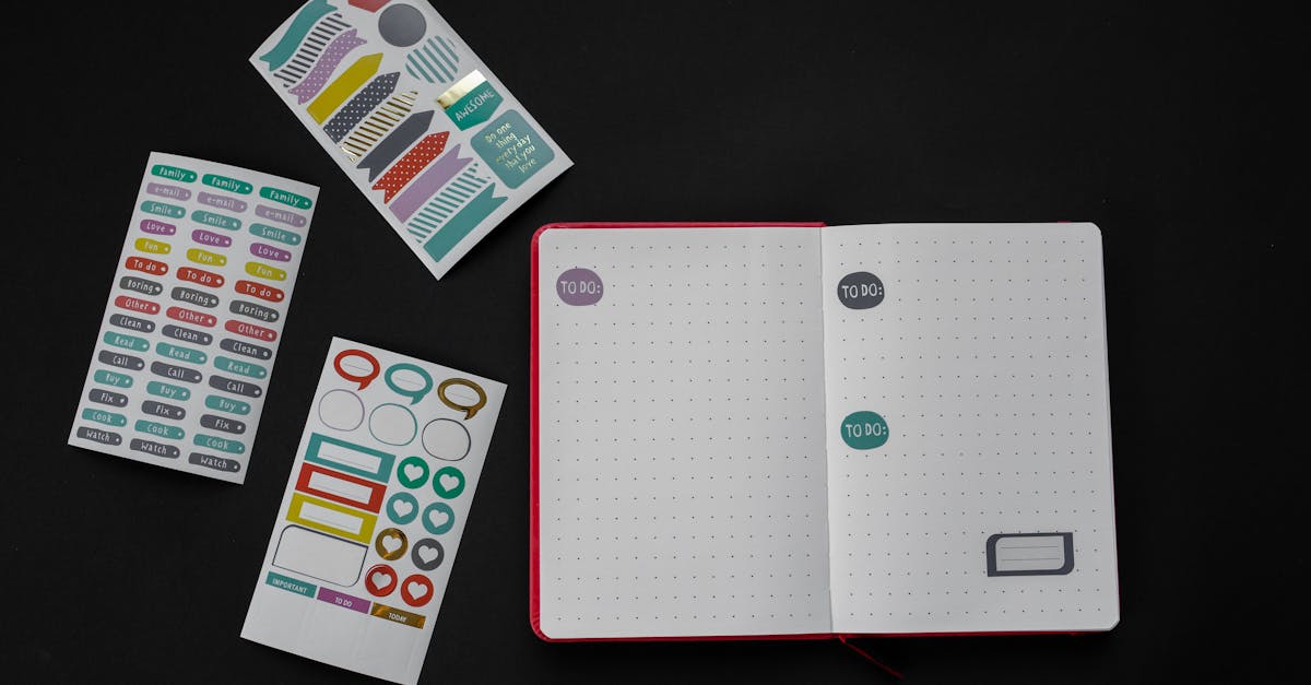 Open notebook with colorful stickers arranged creatively on a black background.