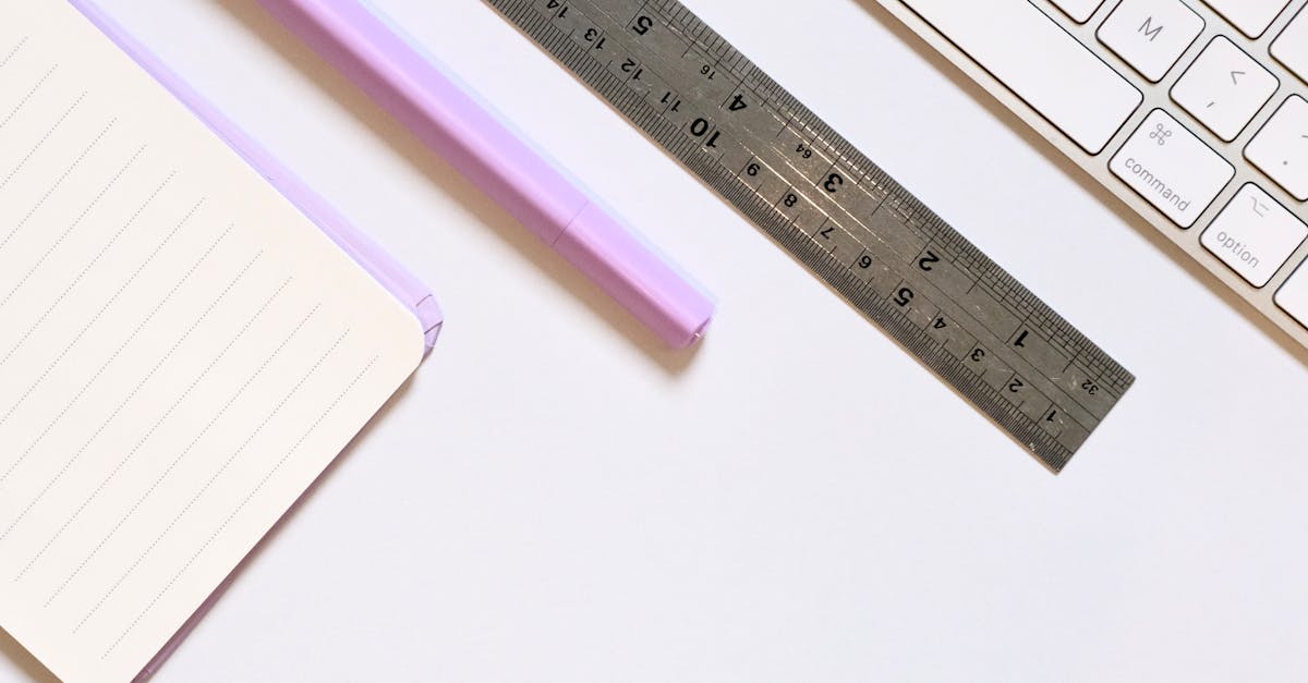 A clean desk setup with a notebook, pen, ruler, and keyboard for productivity and organization.