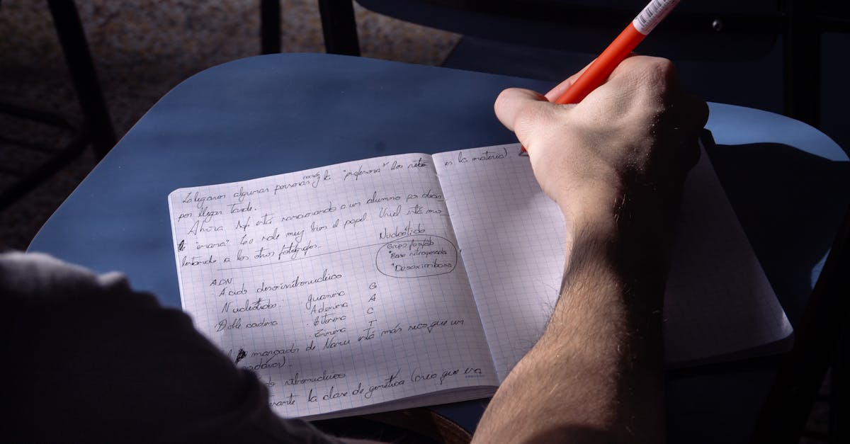 A student takes notes in a classroom in Buenos Aires. Natural lighting highlights the writing process.