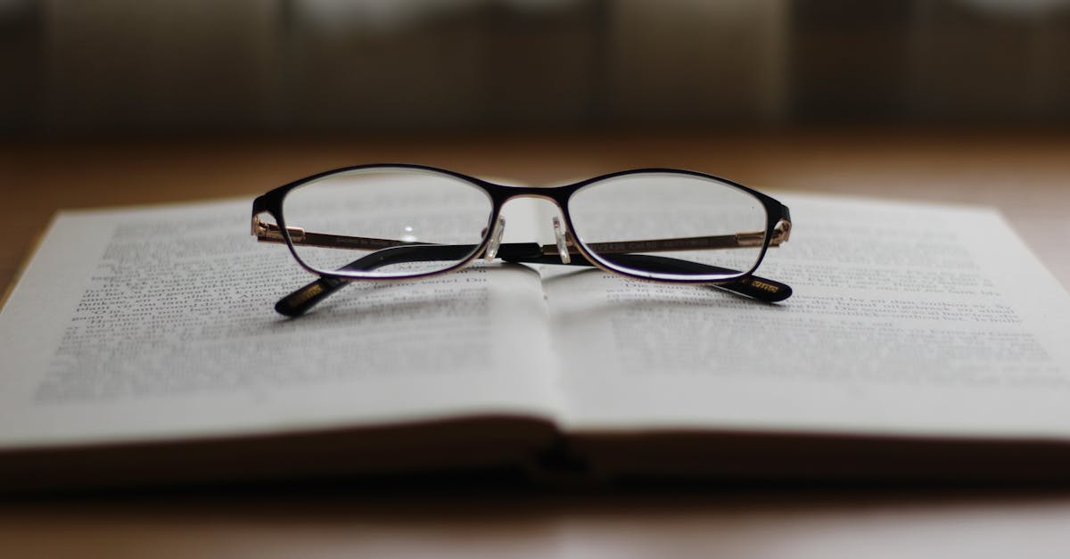 A pair of reading glasses resting on an open book, creating a cozy reading ambiance.