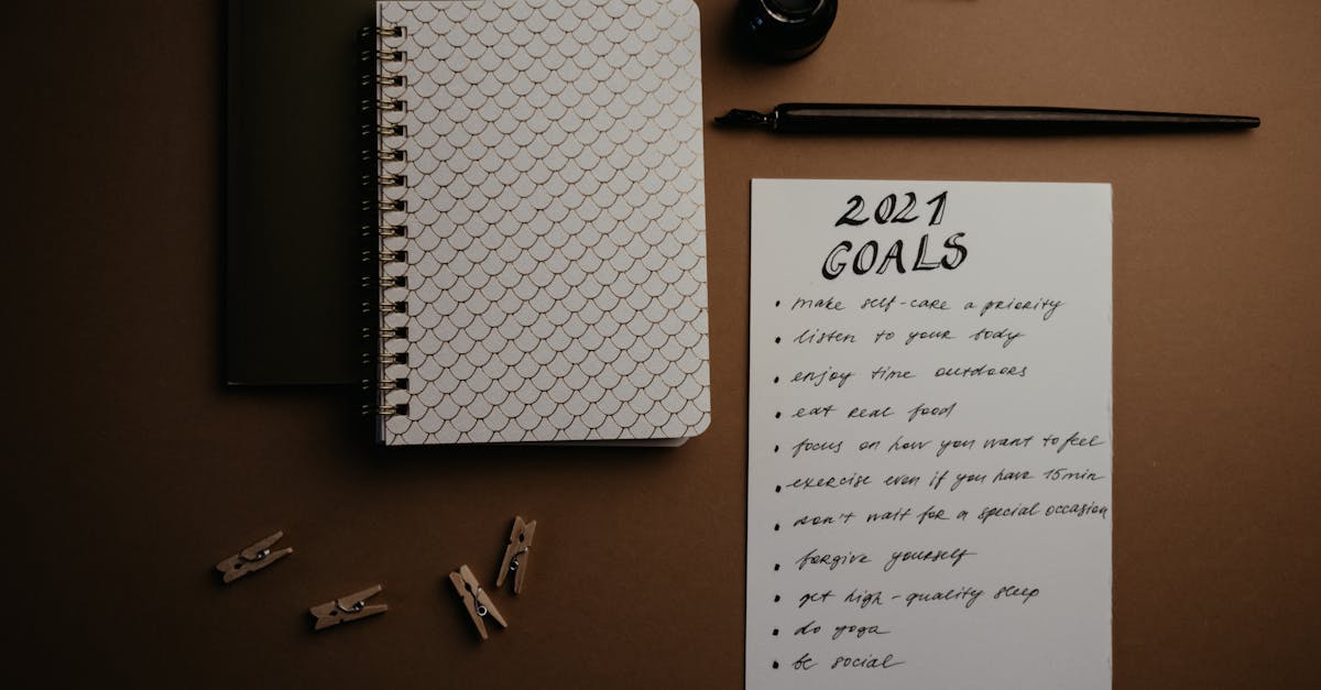 Aesthetic flatlay of notebooks and a 2021 goals list in elegant calligraphy.