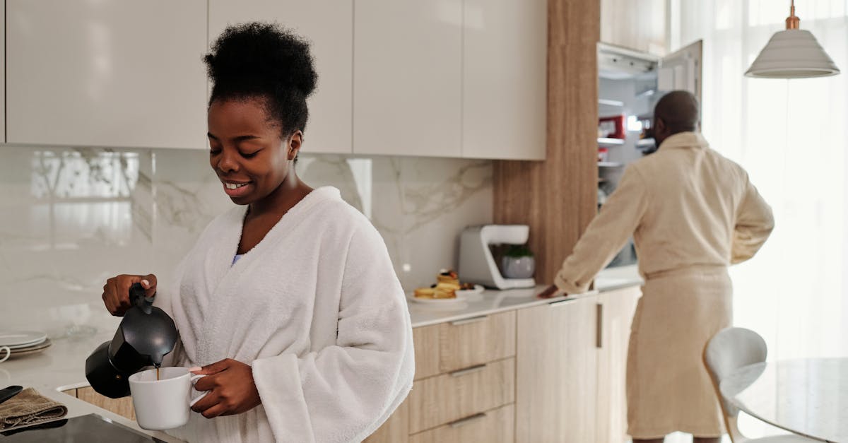 A couple preparing breakfast coffee in a bright, modern kitchen, starting the day.