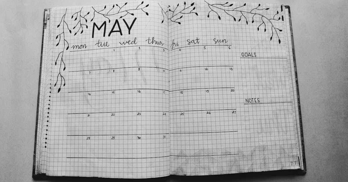 Open notebook displaying a minimalist May planner with handwritten days and decorative elements.