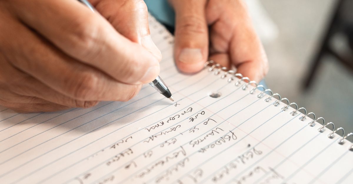 Detailed image of hands writing in a notebook, emphasizing creativity and organization.