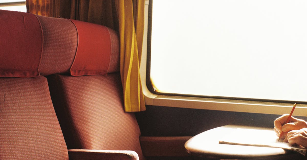 A traveler writes by a train window, capturing the essence of a quiet journey.