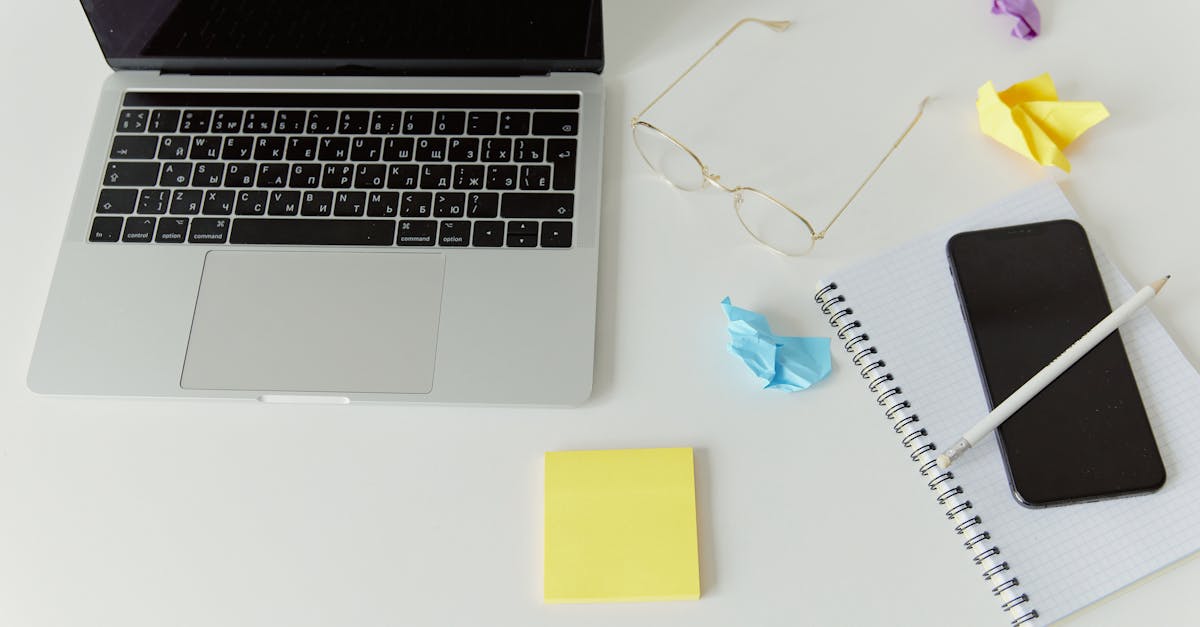 A minimalistic office desk with a laptop, notepad, and crumpled paper for productivity.