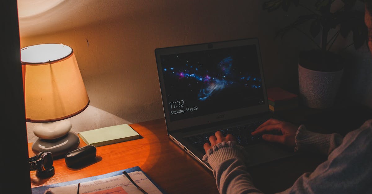 Warmer Arbeitsplatz mit Laptop und Tischlampe.