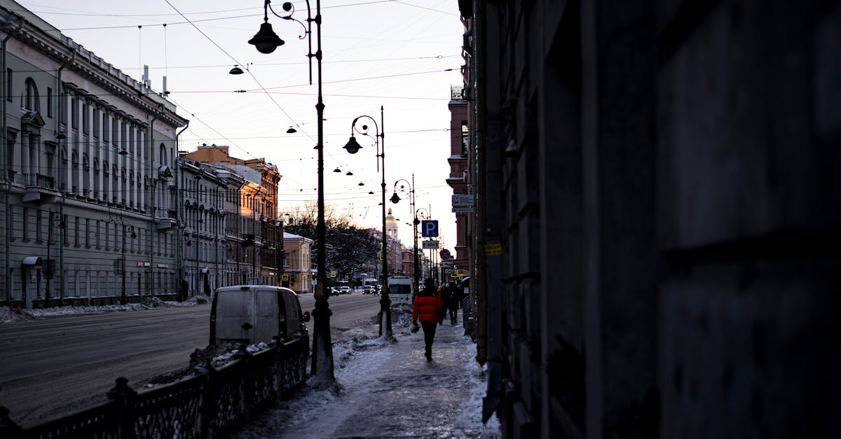 A quiet, snow-covered street in winter with vintage streetlights and urban architecture in the early morning l