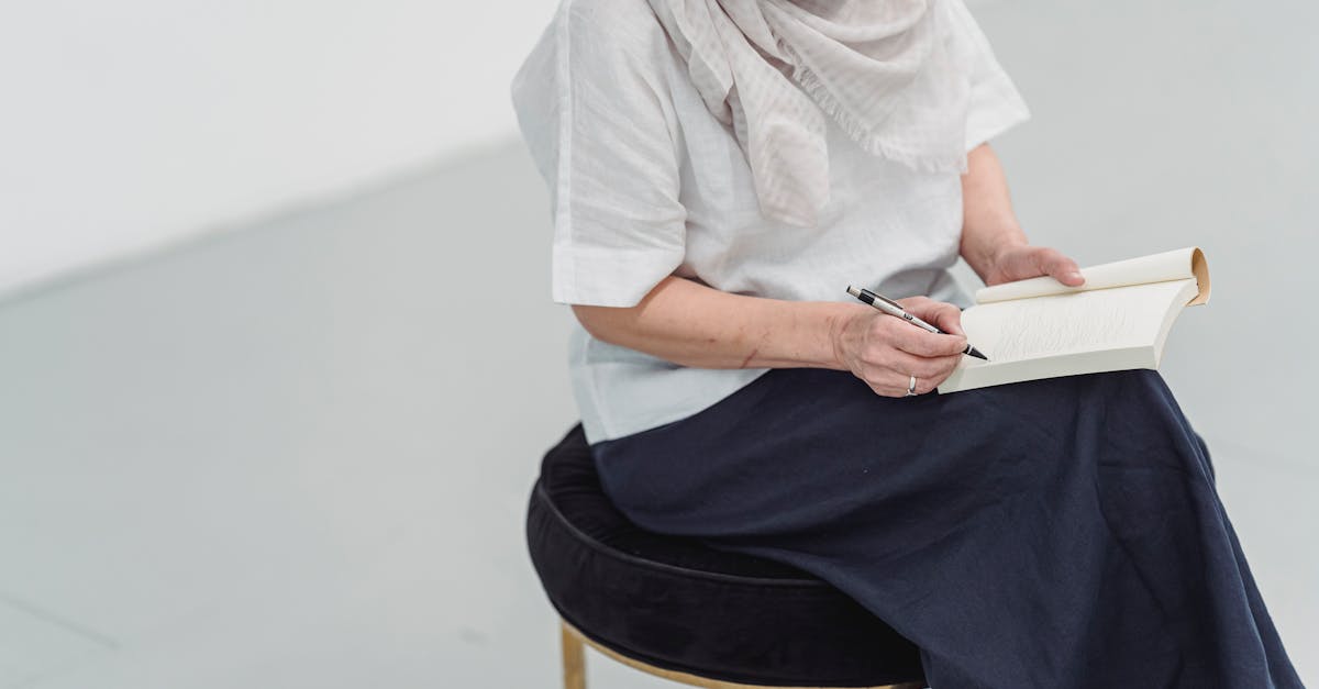 A woman sits writing in a journal, capturing her thoughts in a minimalist setting.